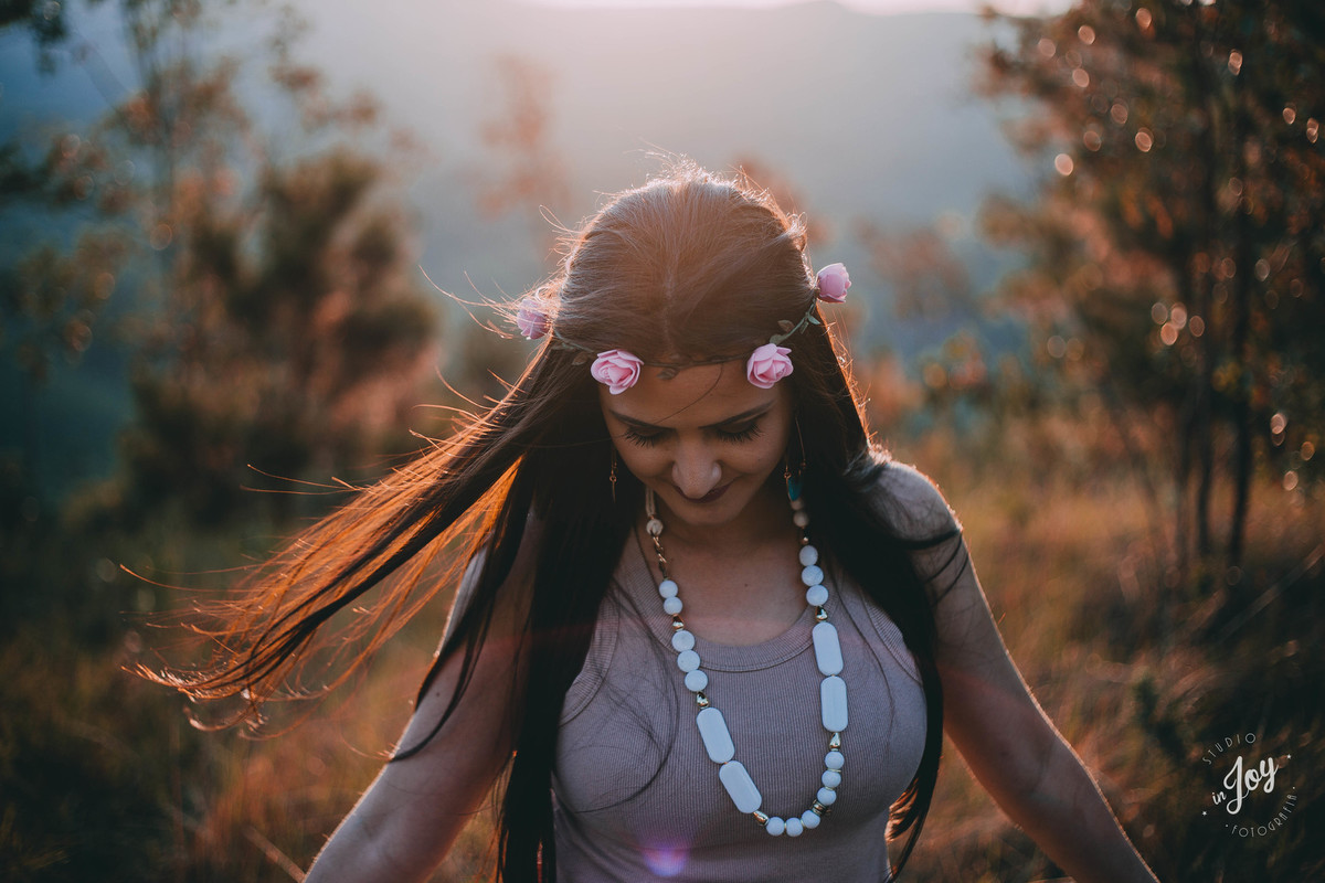 modelo deixando o vento bater em seus cabelos e caminhando pela montanha durante um ensaio fotografico feminino