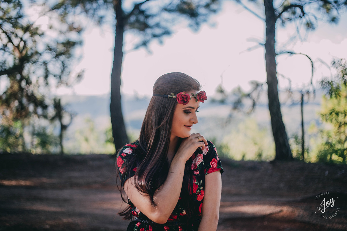 retrato feminino em que a modelo esta com a mão no ombro, olhando para o lado e com uma tiara de flores