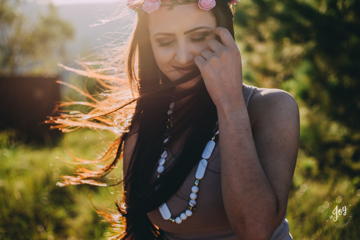 fotografia no por do sol da e a modelo está tirando o cabelo do rosto