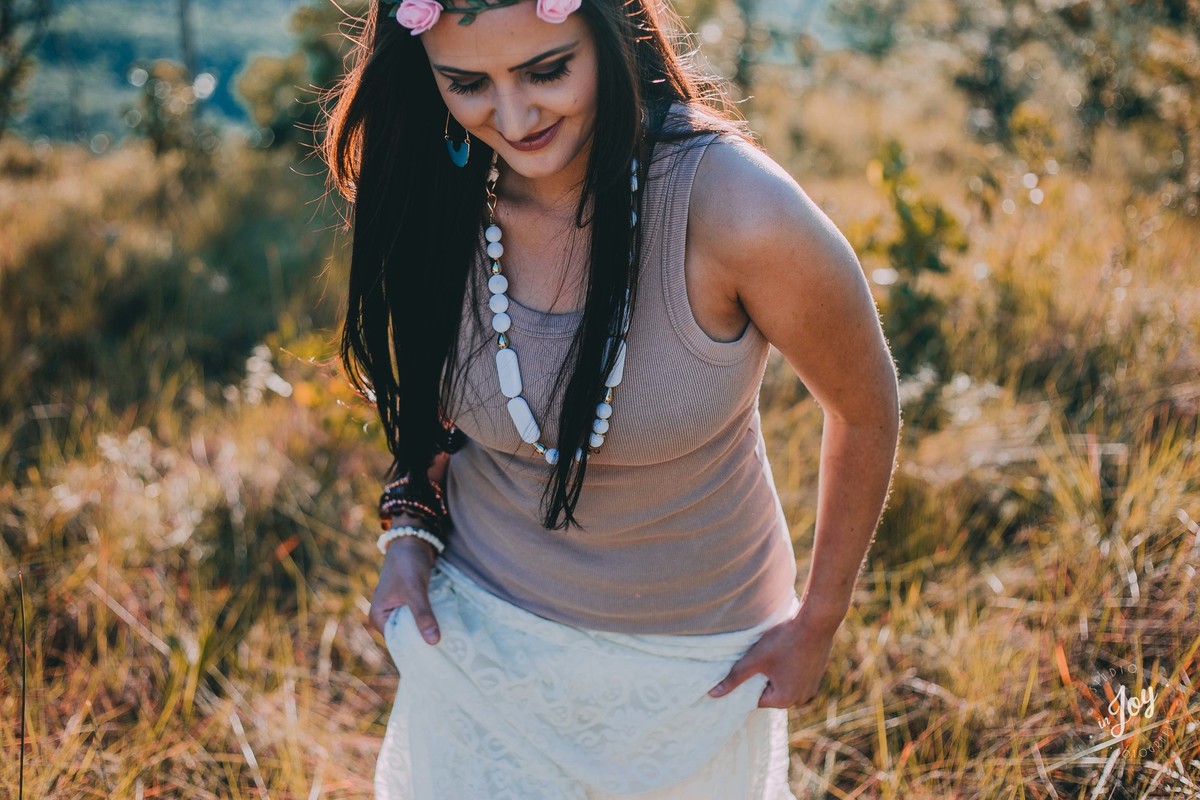 modelo caminhando pelo campo segurando uma saia branca