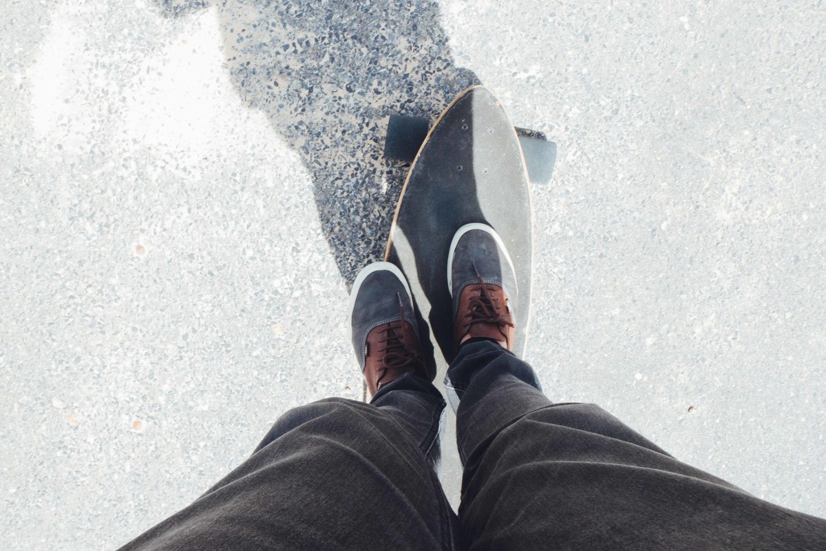 homem com tenis Vans encima do longboard