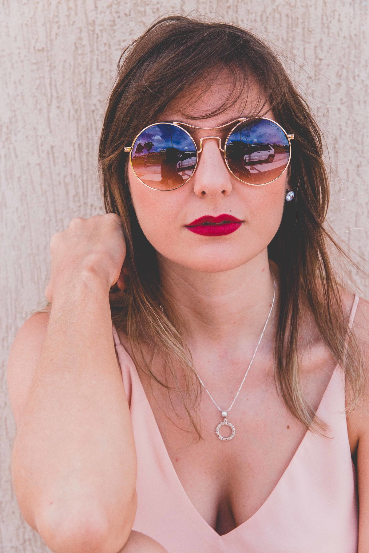 Ensaio feminino em Betim em que a mulher esta sentada encima de um long board e olhando para a camera com um oculos escuro