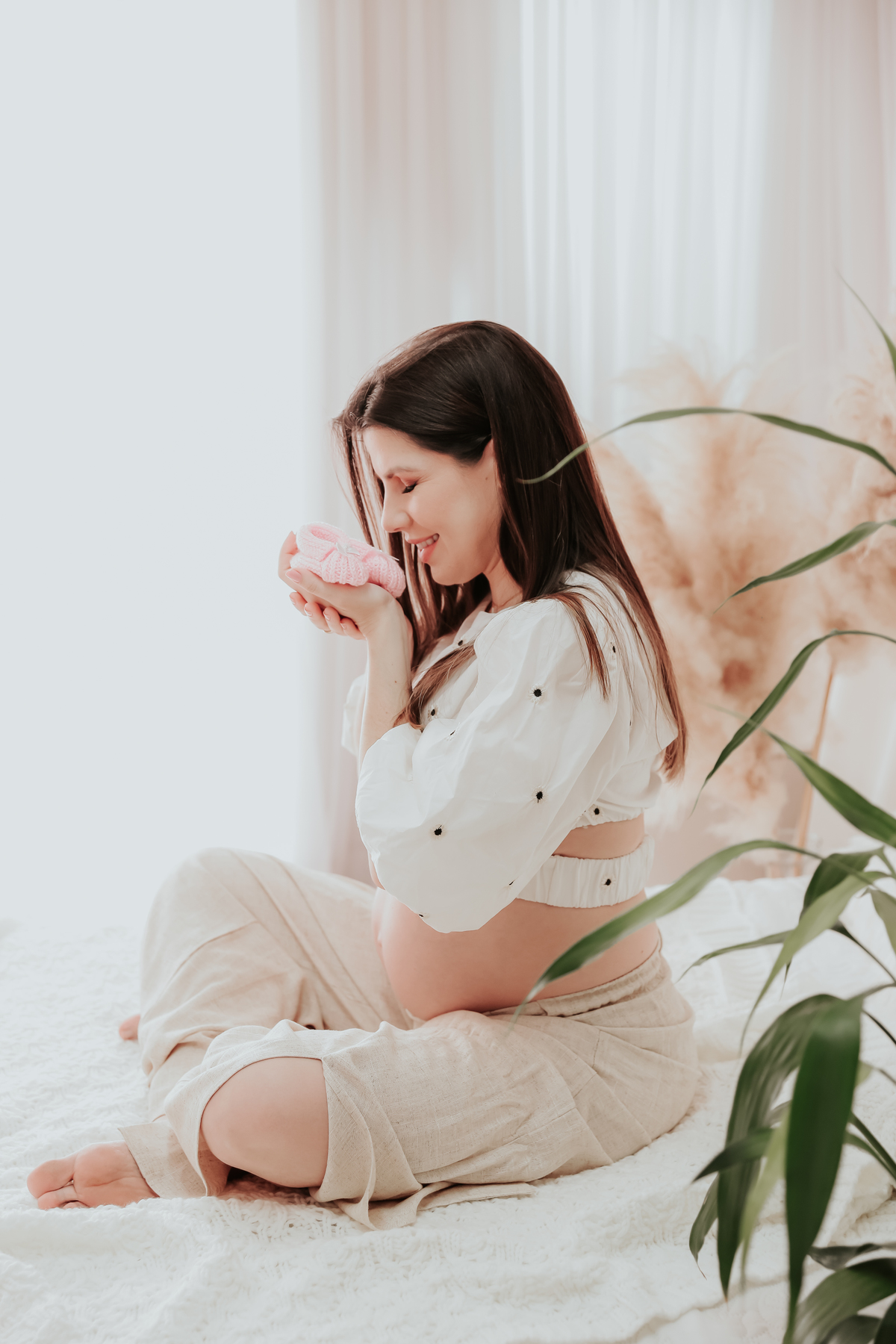 Gestante segurando sapatinho 