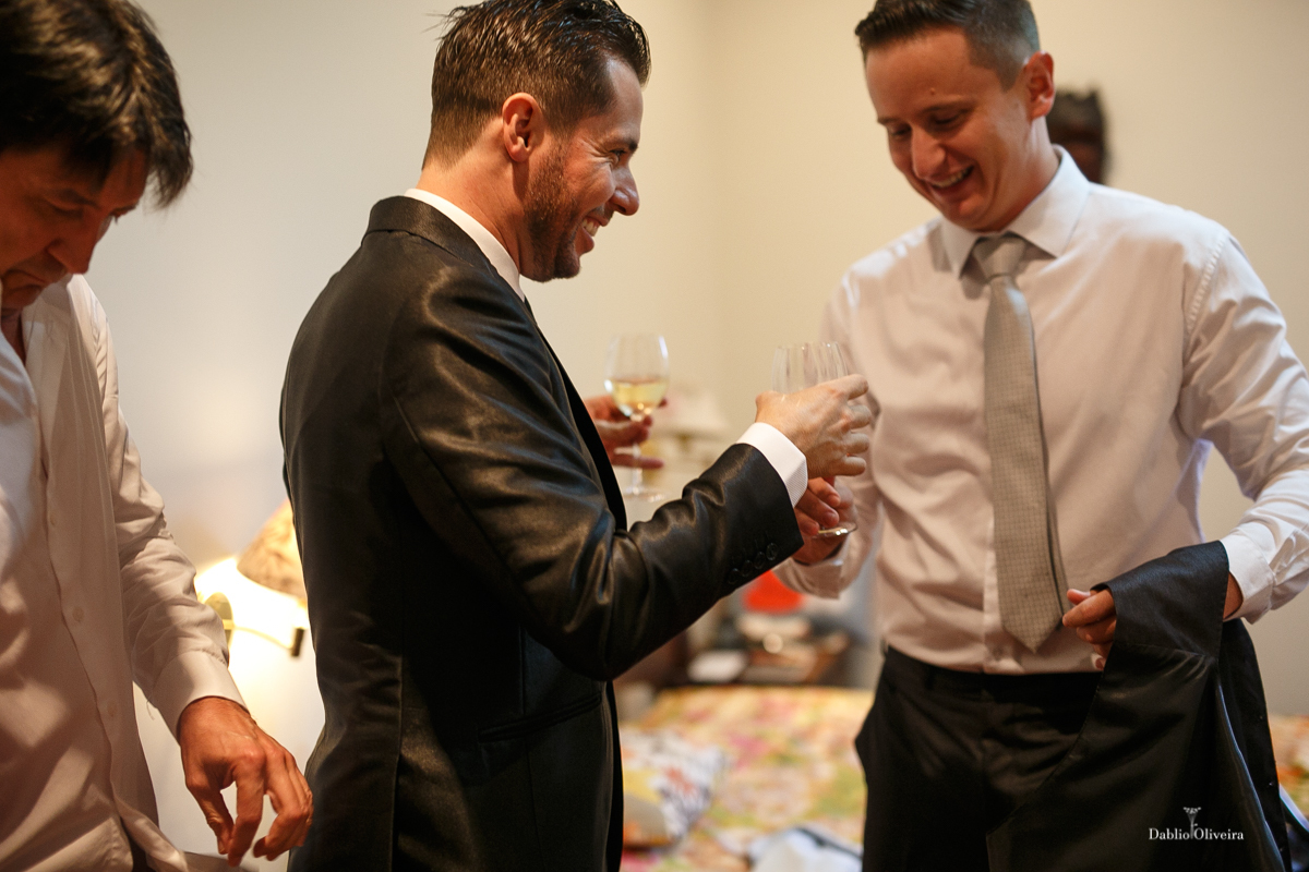 amigos chegam com champagne para brindar o casamento junto com o noivo