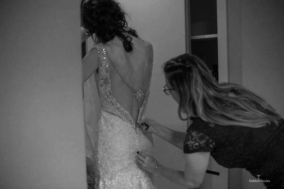 estilista fechando o vestido da noiva