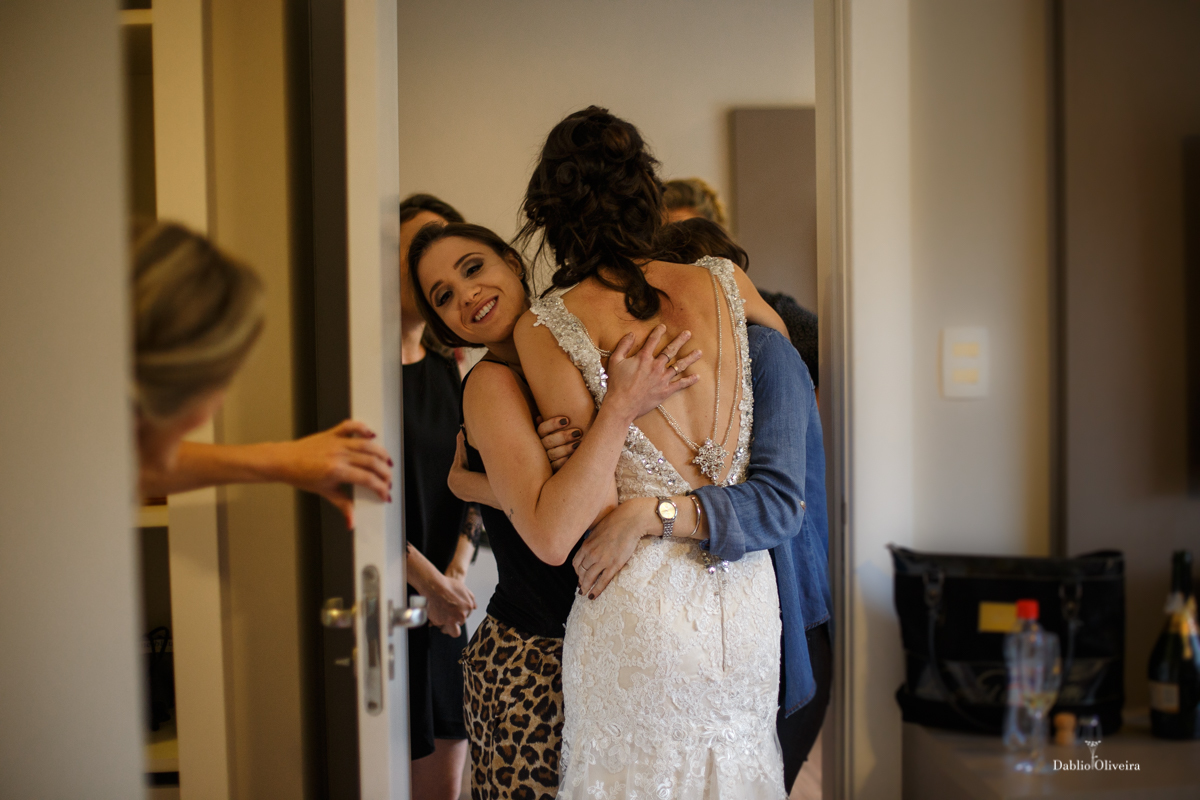 noiva pronta é abraçada por madrinhas