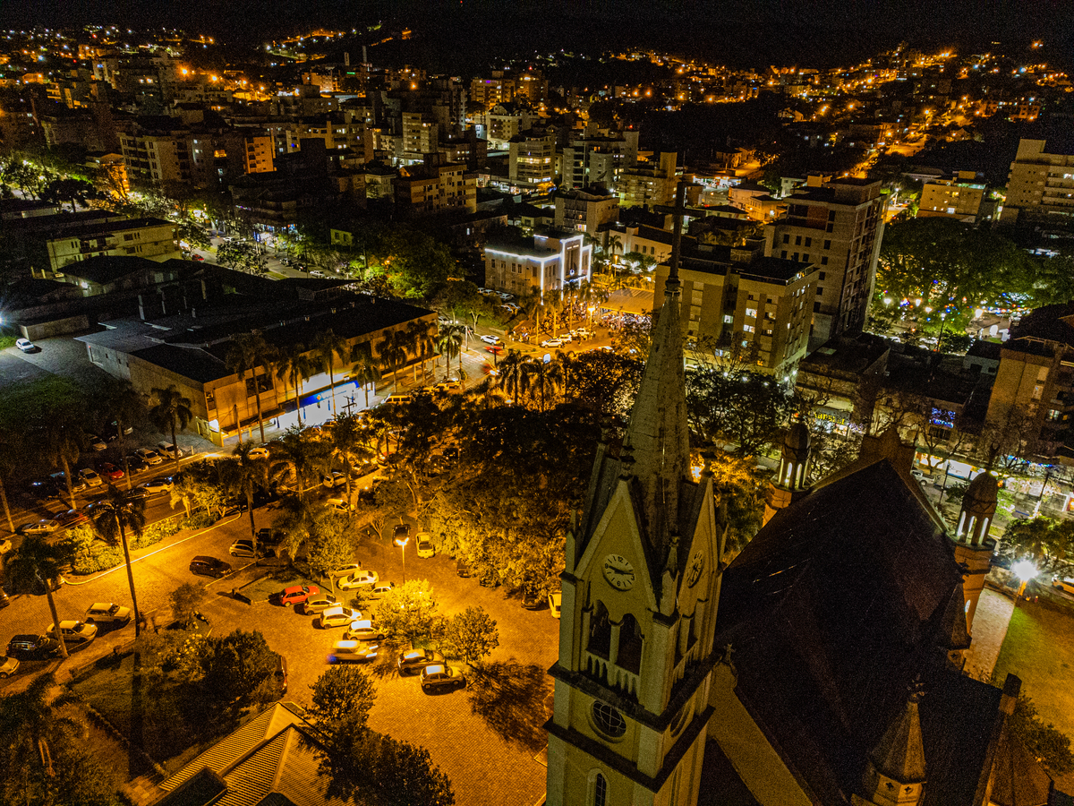 imagem da Igreja Matriz São João Batista e o espetaculo do Bailado Gaucho aos fundos da imagem. 