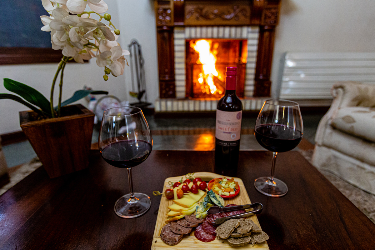 Lareira, tabuas de frio e vinho  na Pousada Bosque Canela. 