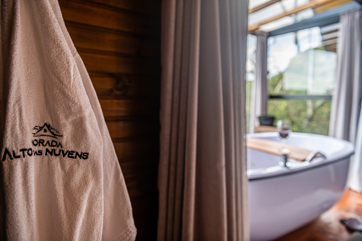 Roupão e banheira nesse frio numa cabana de madeira. 