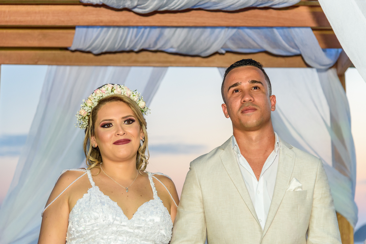 Noivos acompanham a entrada dos pagens trazendo as alianças durante a celebração do casamento na praia de camboinhas no Quiosque Harmonia, Niterói - RJ