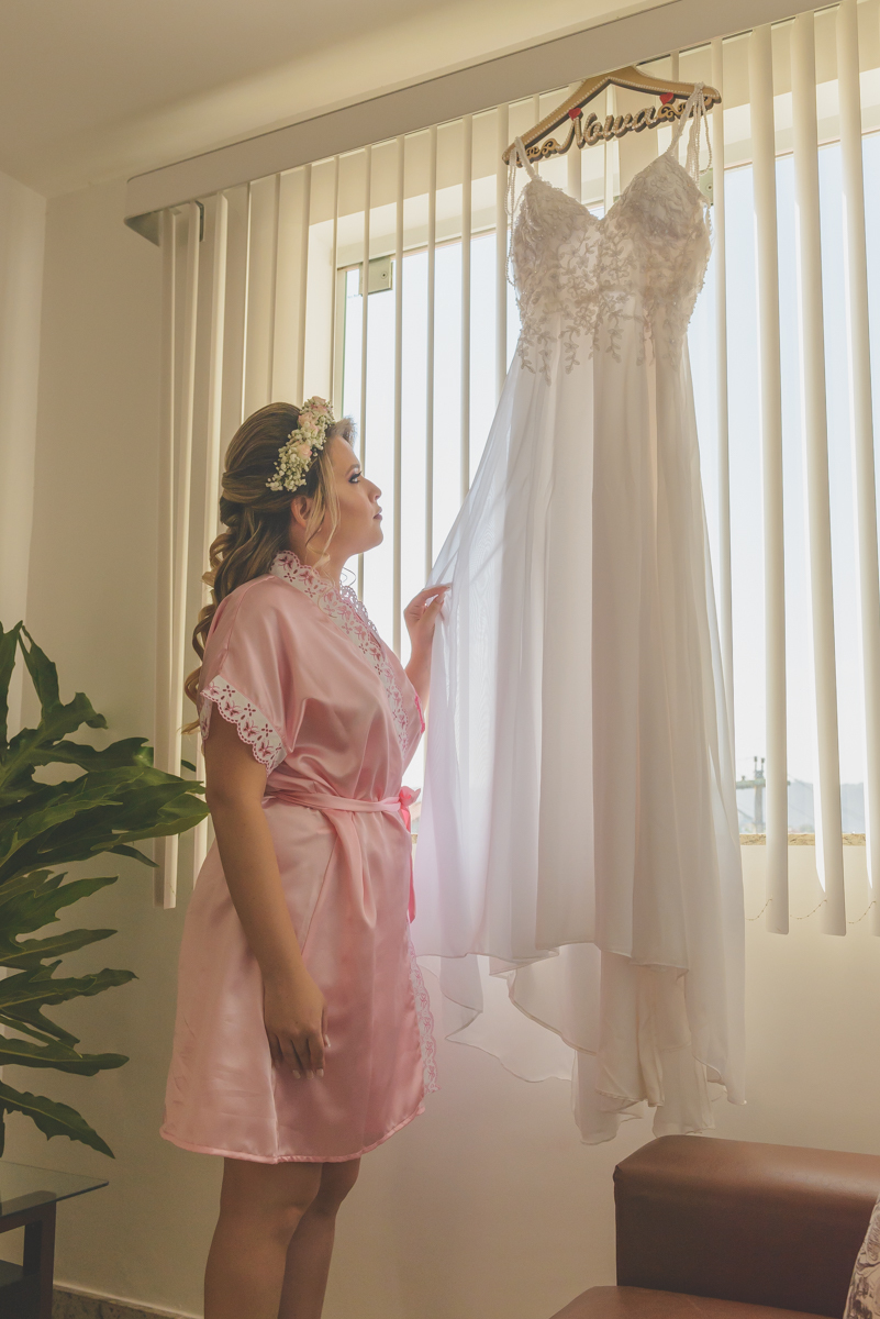 Noiva olhando para o seu vestido de noiva, Camboinhas - RJ