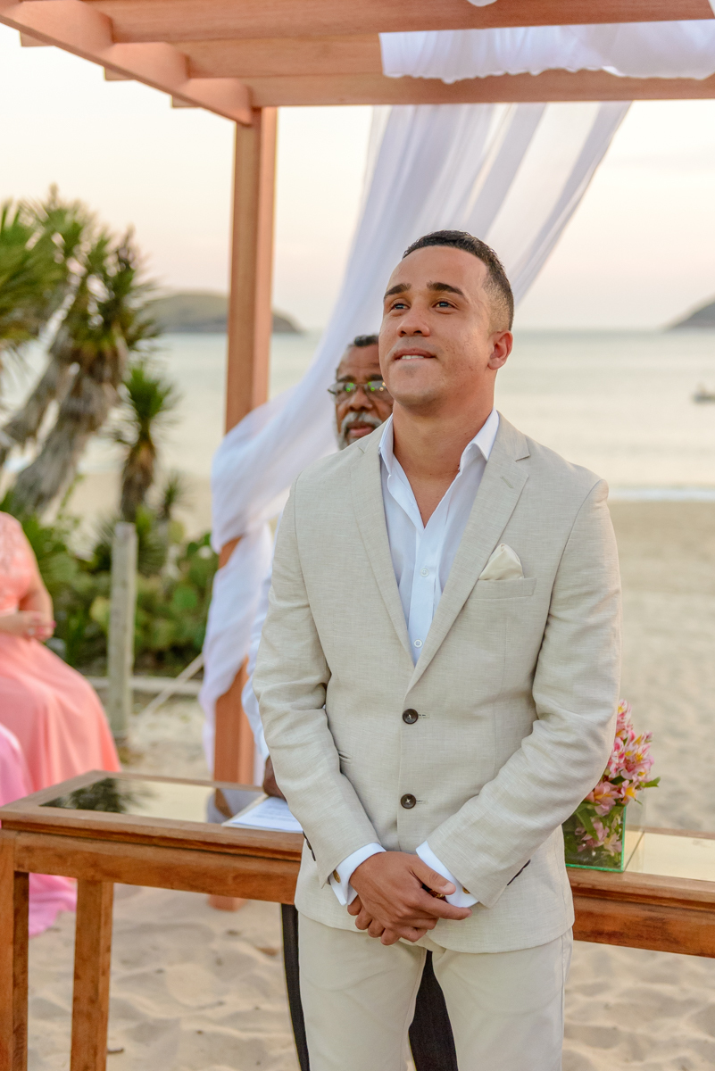 Noivo olhando a entrada da noiva na cerimônia de casamento na praia, Niterói - RJ