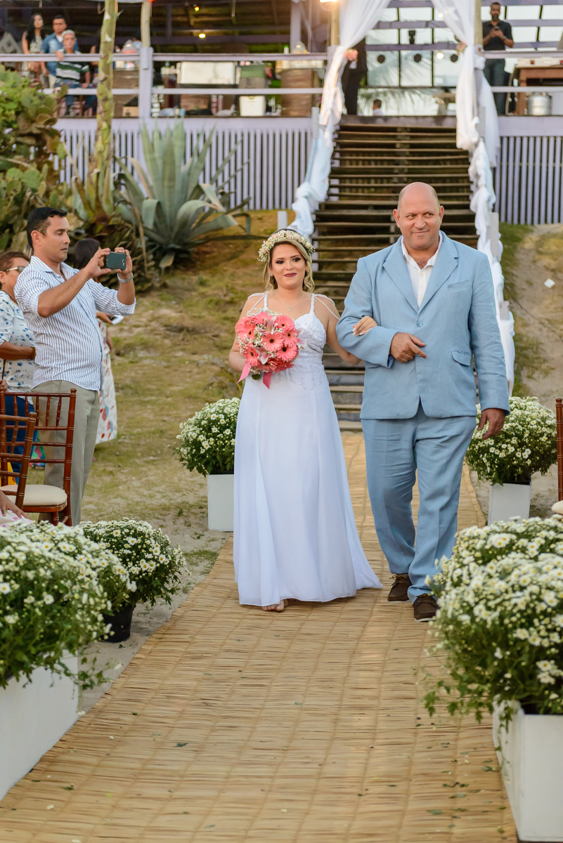 Noiva com buquê durante sua entrada na cerimônia de casamento na praia de Camboinhas, Niterói - RJ