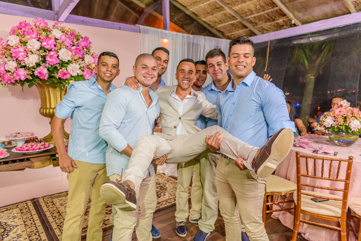 Padrinhos levantam o noivo na festa de casamento no quiosque harmonia na praia de camboinhas, Niterói - RJ