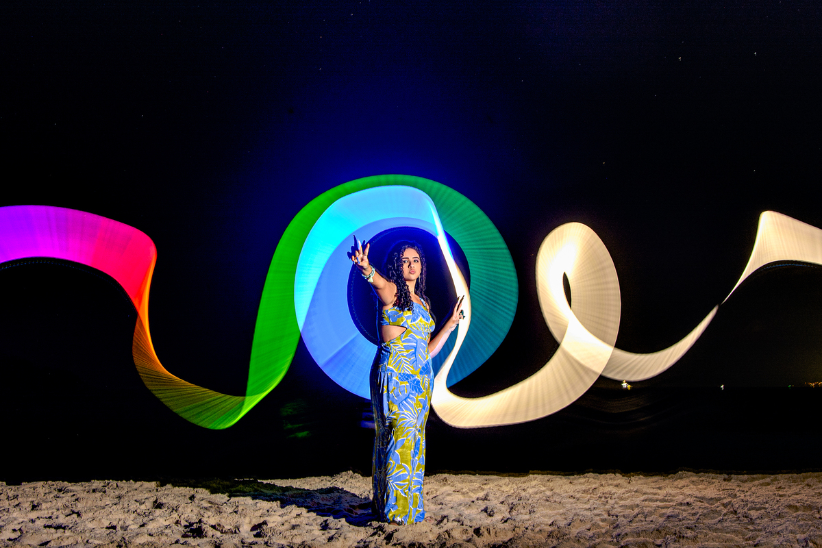 Fotografia de debutante com iluminação feita com bastão de Led na praia de Camboinhas, Niterói - RJ