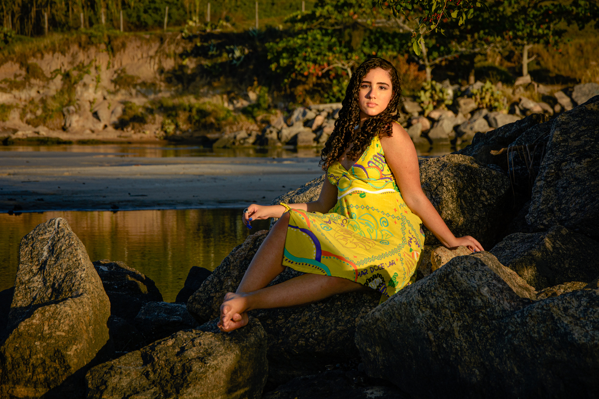 fotografia da debutante sentada nas pedras do canal de Itaipú, Camboinhas - Niterói
