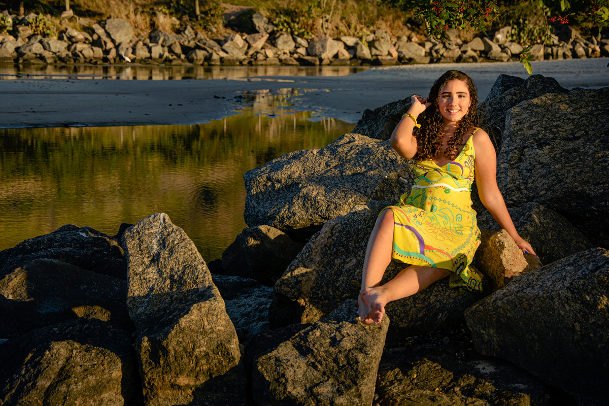 Ensaio fotográfico de debutante sentada na pedra em Camboinhas, Rio de Janeiro - RJ