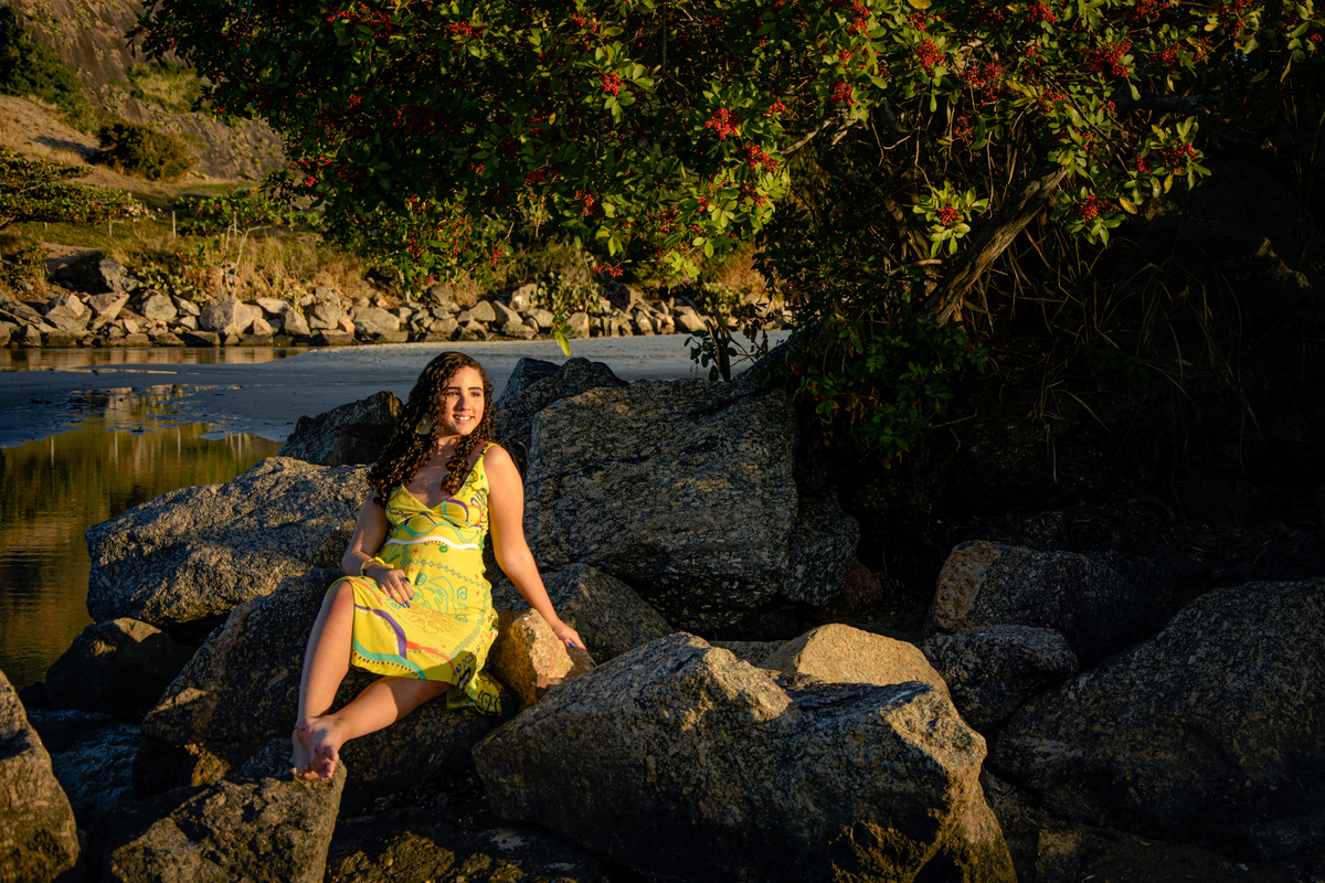 Ensaio fotográfico de debutante sentada na pedra em Camboinhas, Niterói - RJ