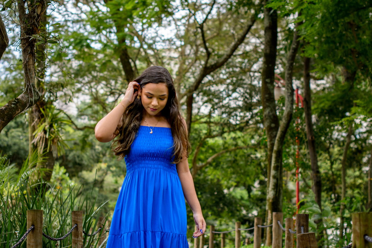 Debutante distraída usando vestido azul em ensaio fotográfico no parque, Niterói - RJ