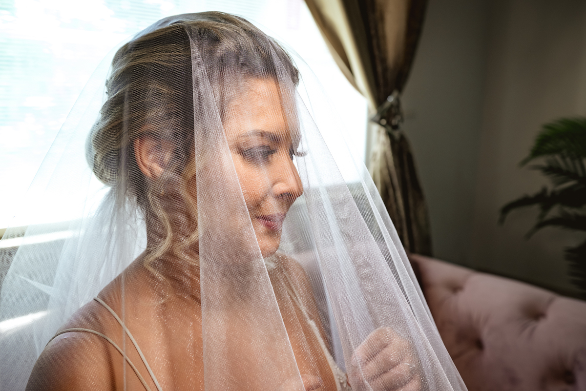 noiva coberta com o véu durante o making of de dia