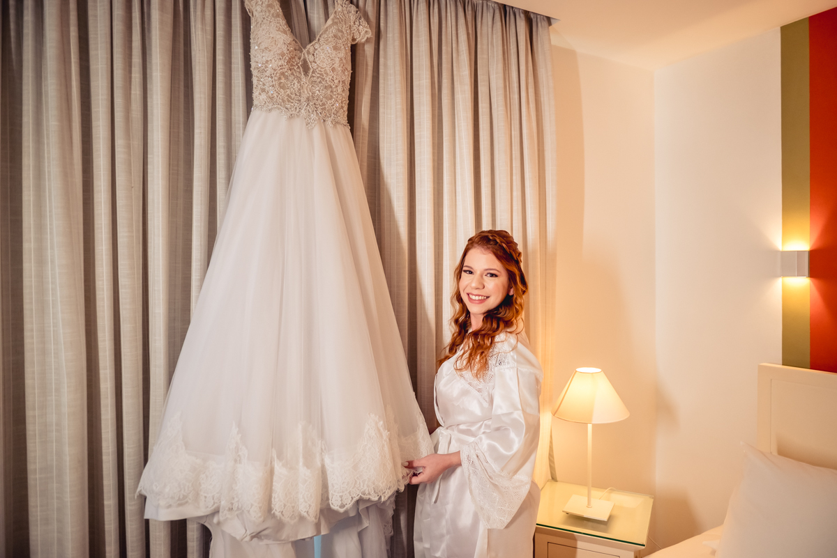 noiva caroll ao lado do seu vestido de casamento durante o making of no hotel Wyndham rio barra - RJ