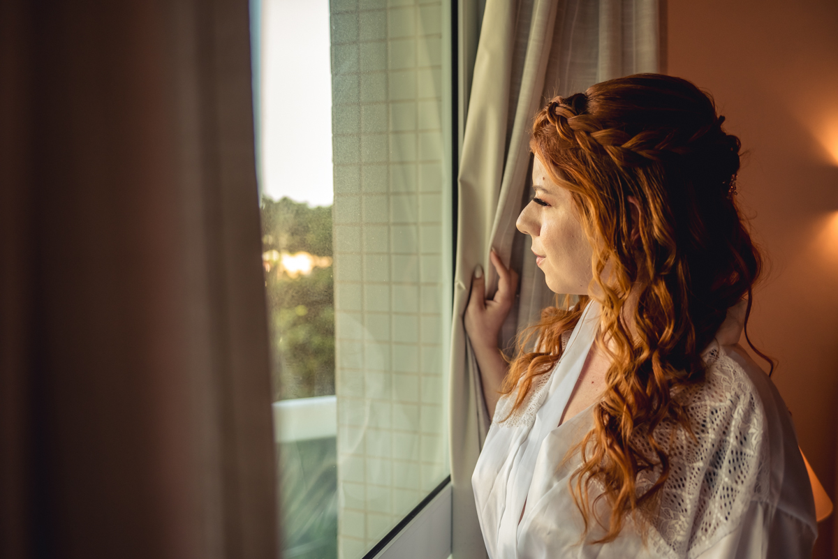 Noiva olhando pela janela antes do casamento na barra da Tijuca - RJ