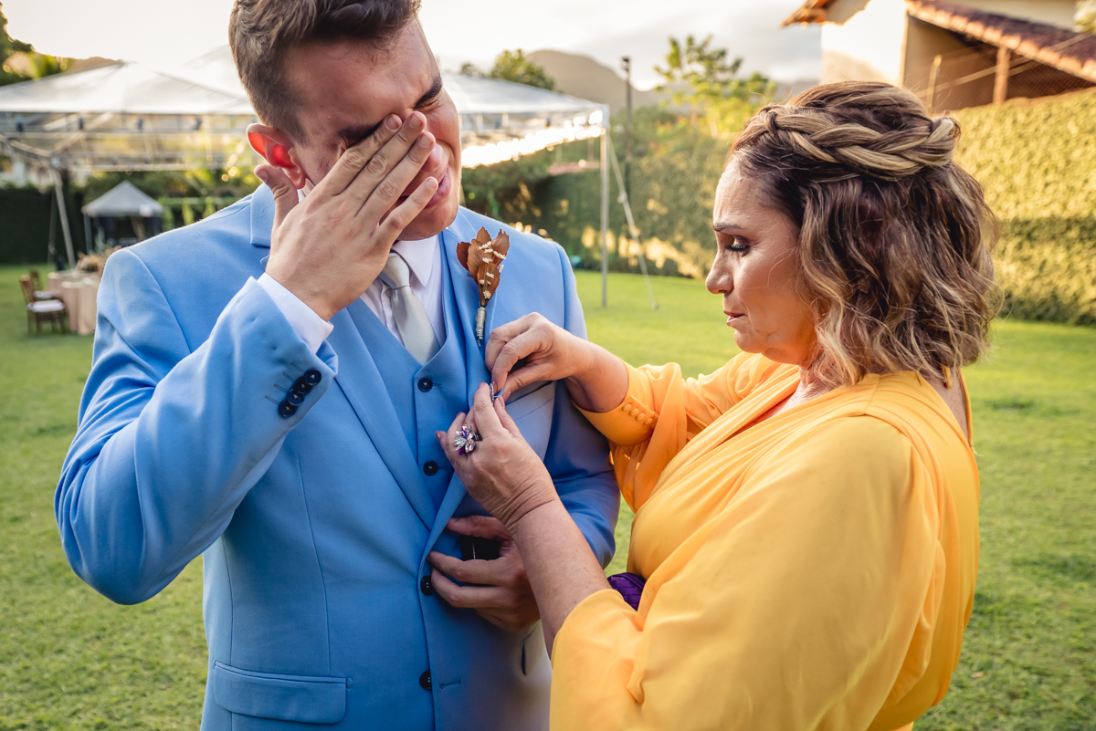Fotografia do noivo emocionado ao receber a lembrança com a foto da irmã falecida na entrada da sua cerimonia de casamento no sitio da paz, Barra da Tijuca - RJ