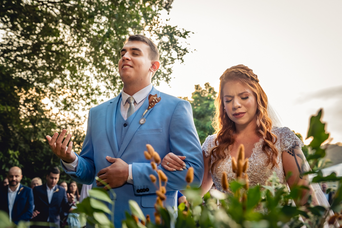 noivos emocionados em frente ao pastor durante a celebração do casamento no sitio na barra da Tijuca - RJ