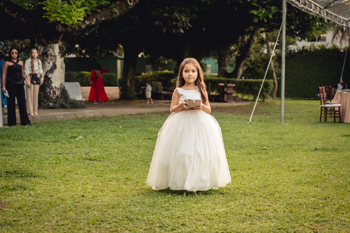 entrada da daminha com vestido branco e trazendo as alianças para a cerimonia de casamento na barra da Tijuca - RJ