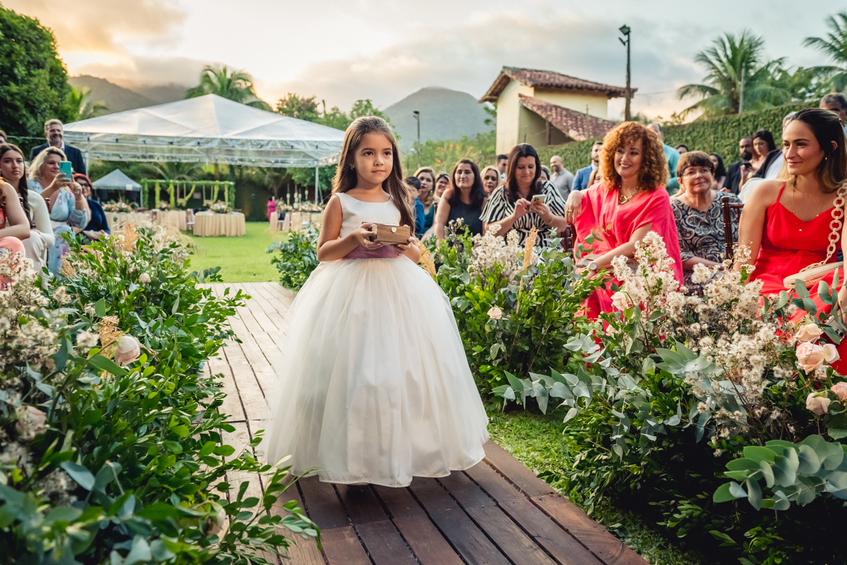 linda entrada da daminha com vestido branco e trazendo as alianças para a cerimonia de casamento na barra da Tijuca - RJ