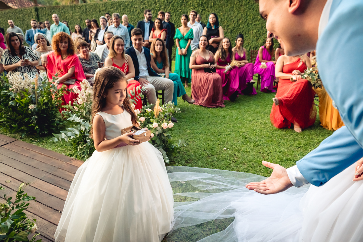 entrada da daminha linda com vestido branco e trazendo as alianças para a cerimonia de casamento na barra da Tijuca - RJ