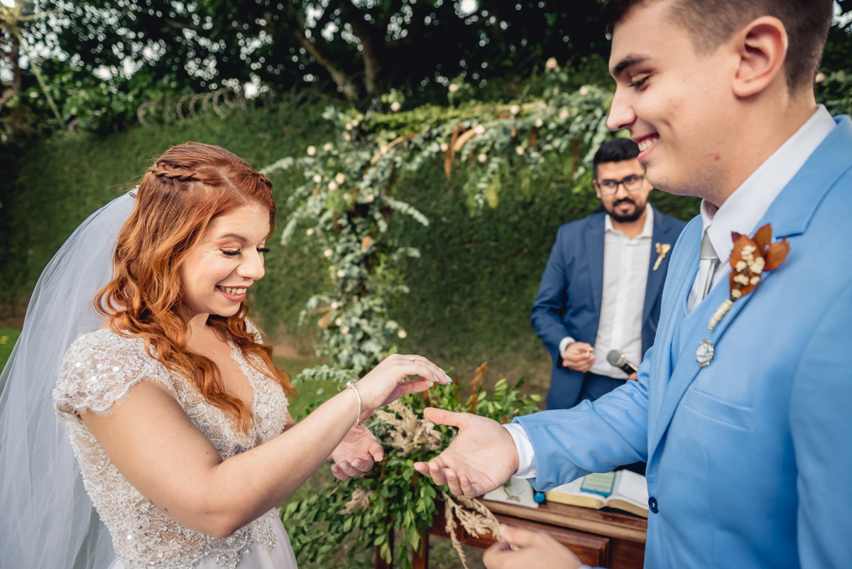 noiva sorri durante os votos realizados pelo noivo durante a celebração do casamento de dia ao fim da tarde no sitio da paz - RJ