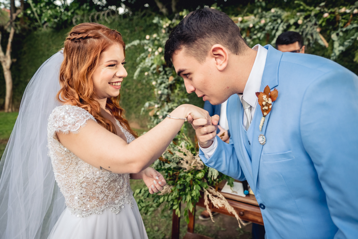 noivo beija a mão da noiva durante a celebração do casamento de dia ao fim da tarde no sitio da paz - RJ