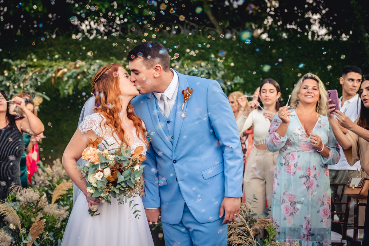 beijo dos noivos com bolhas de sabão ao fundo após a cerimonia de casamento no sitio no fim de tarde na barra da Tijuca - RJ