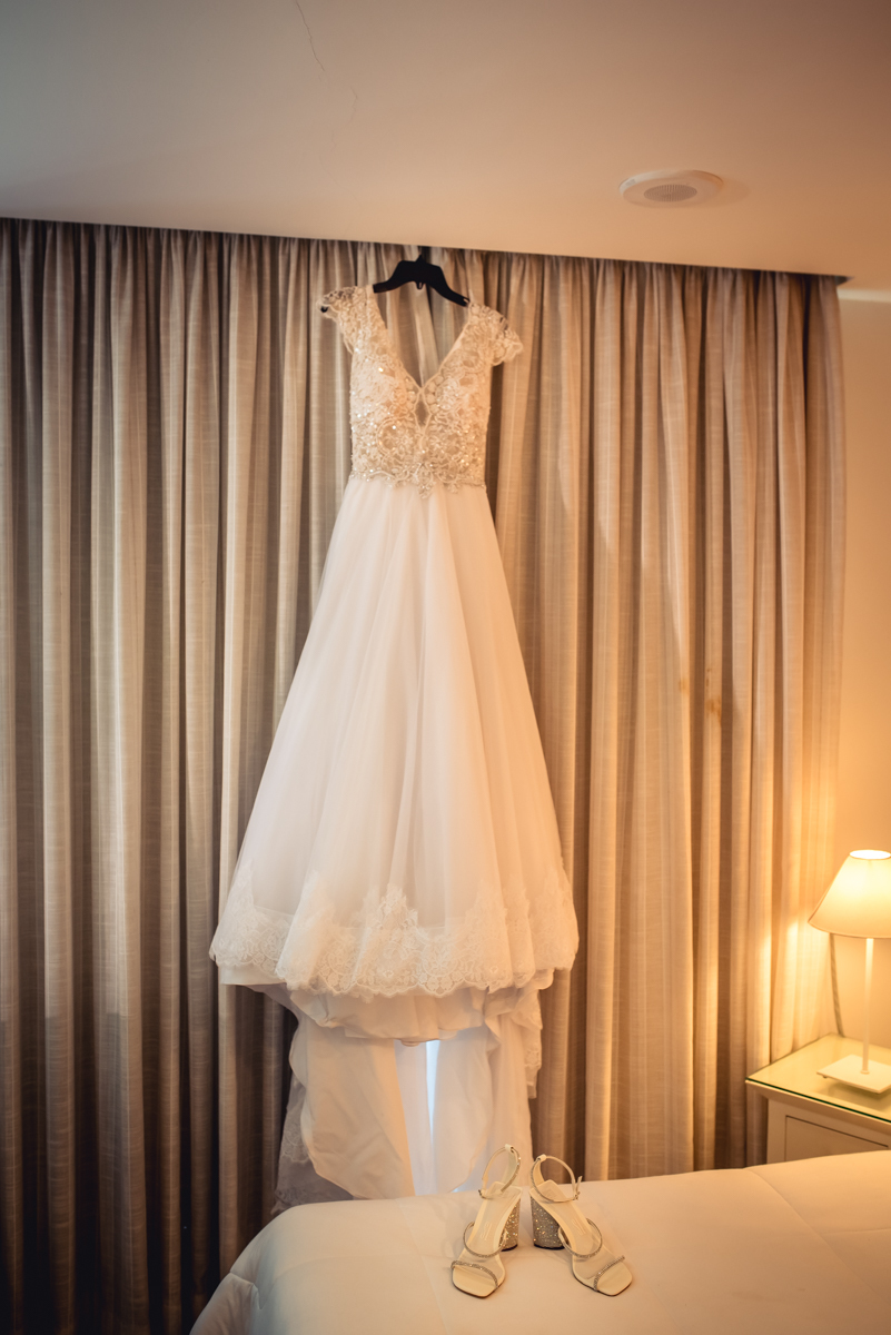 Vestido da noiva e sapatos durante o making of sapatos da noiva em cima da cama durante o making of no hotel Wyndham rio Barra - RJ