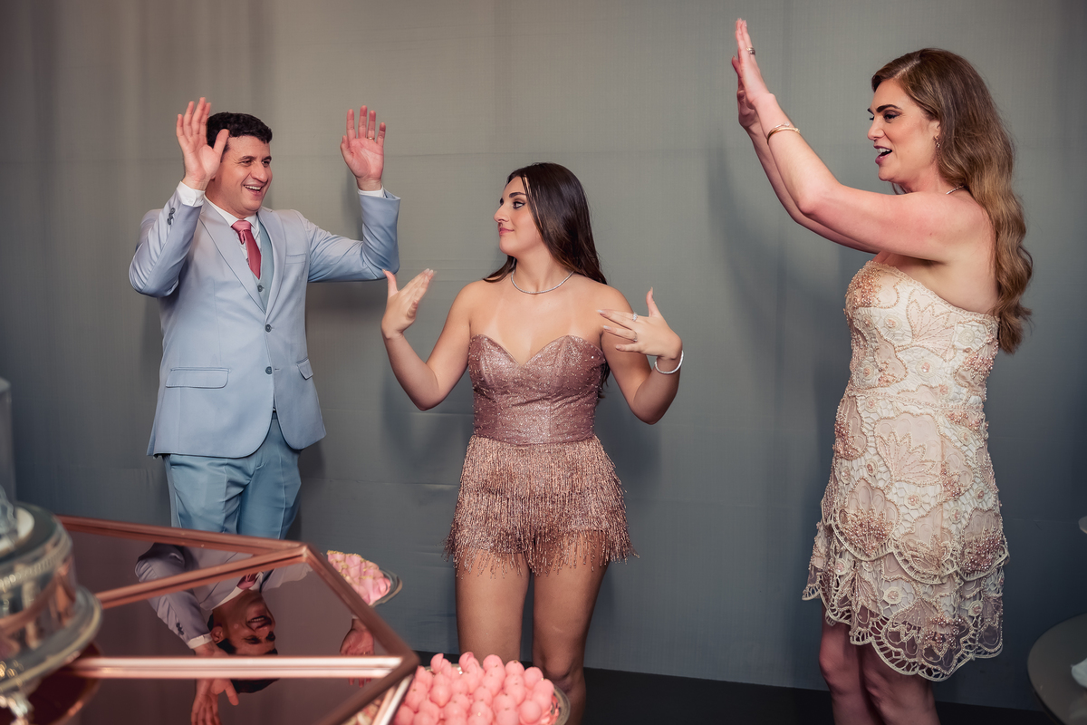 foto com a debutante isabella no momento dos parabéns na mesa do bolo na casa das canoas - São Conrado