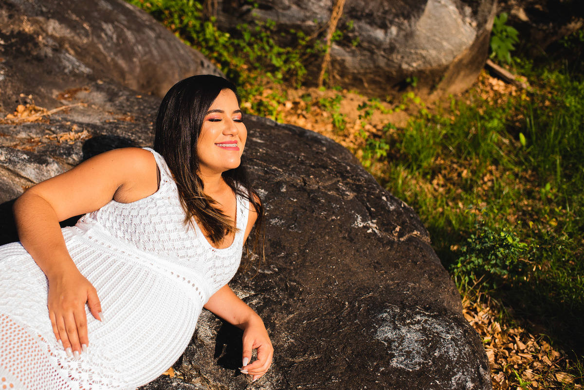 Mamãe deitada numa pedra acariciando sua barriga enquanto uma linda luz chega até ela.