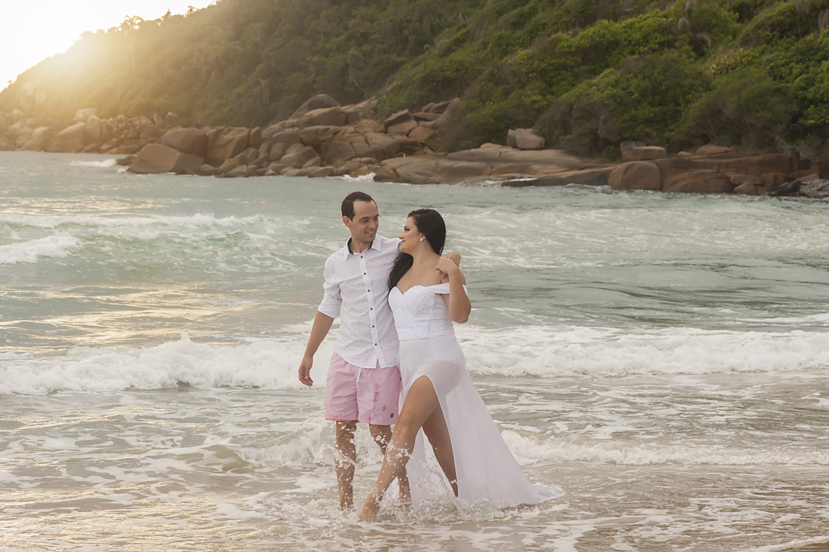Pré-wedding na praia brava casal caminhando na beira da praia