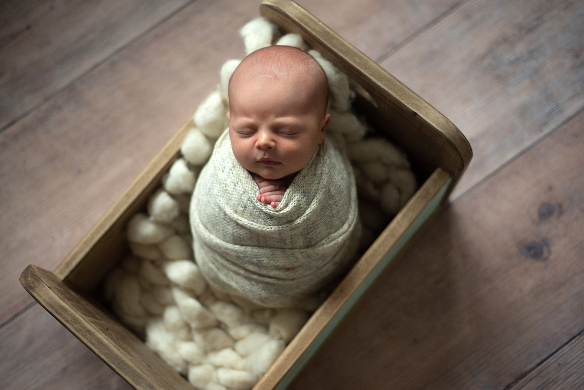 Luis Henrique deitado na caminha de madeira usando wrap bege