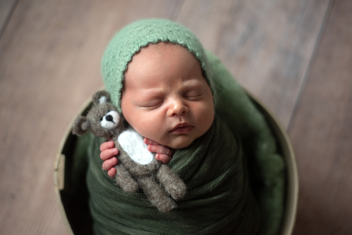 Newborn com ursinho feltrado na mão