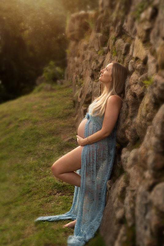 Gestante de vestido azul encostada no paredão do Forte em Florianópolis