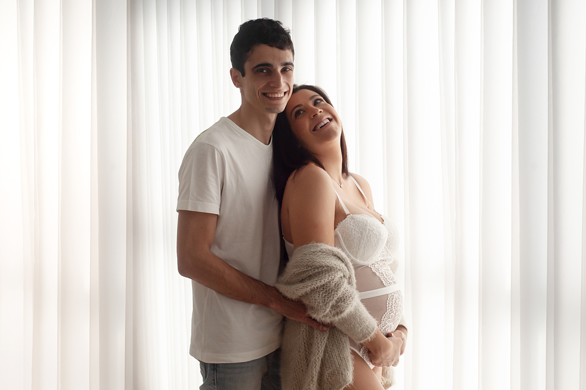 Cortina branca atrás casal está sorrindo