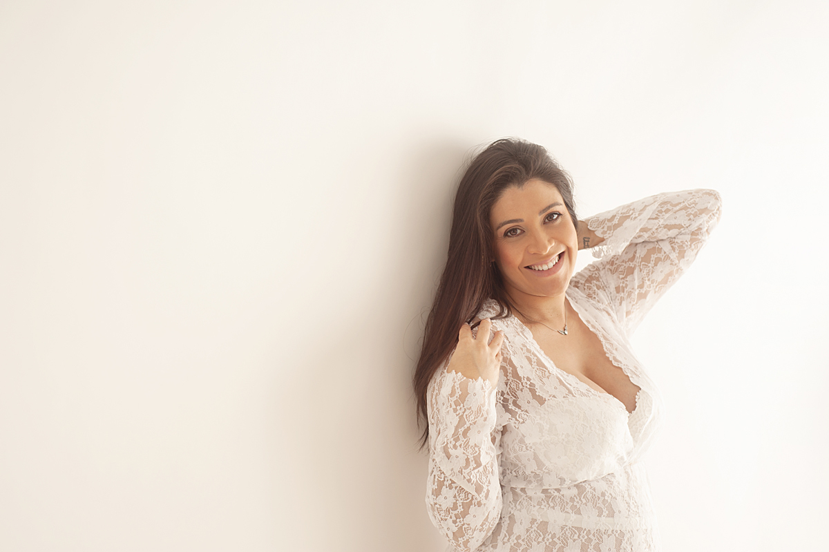 Gestante vestida de branco ensaio sorriso natural