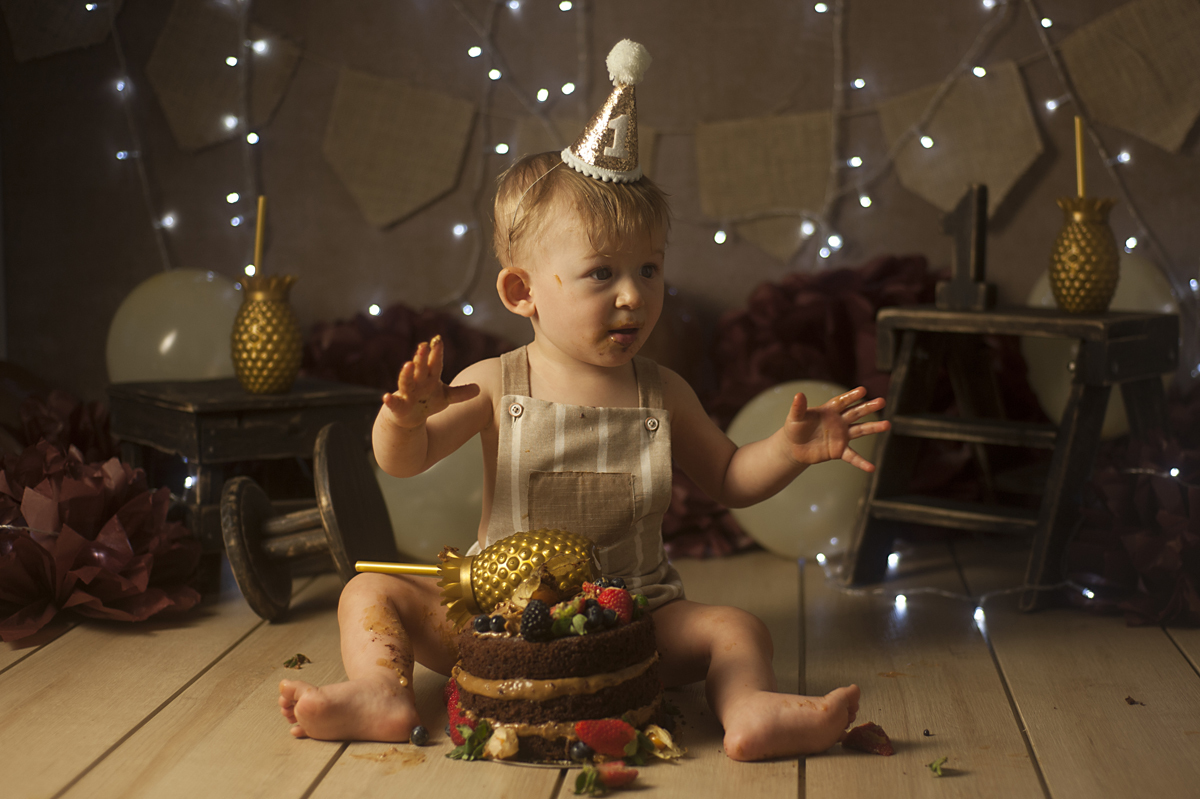 Bebê com bolo no cenário neutro