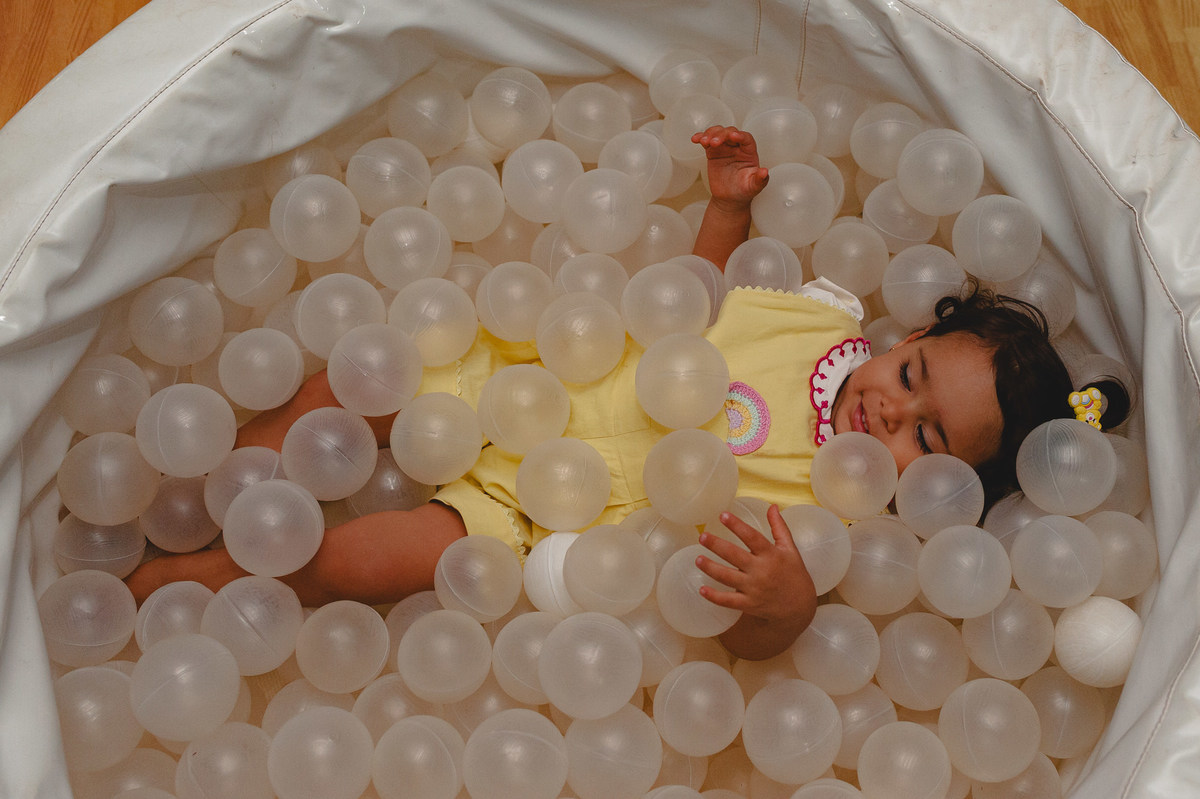 Menina brincando em piscina de bolinhas