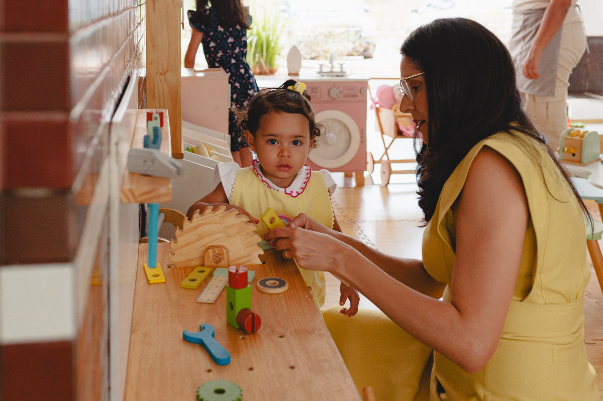 Menina e mãe brincando em set de ferramentas