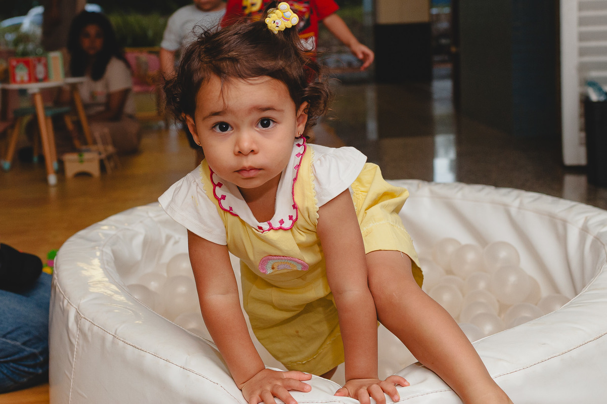 Menina saindo da piscina de bolinhas