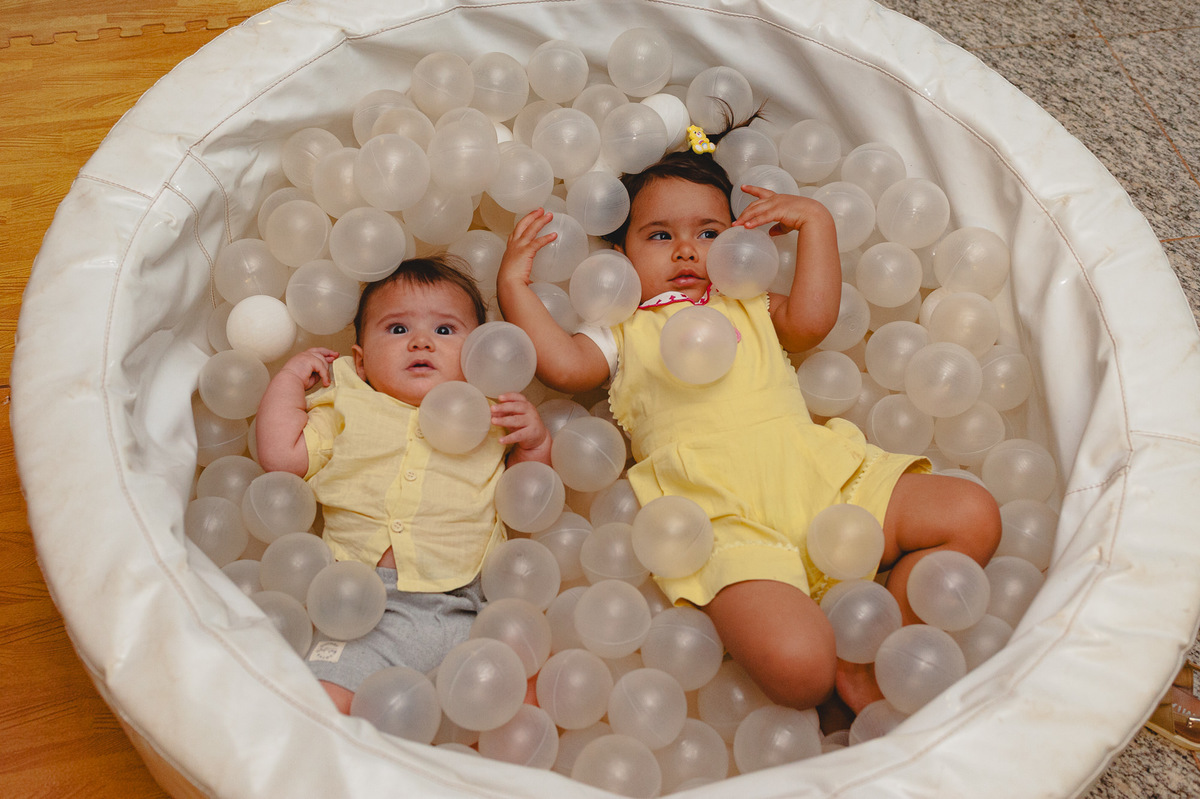 Menina e bebê na piscina de bolinhas