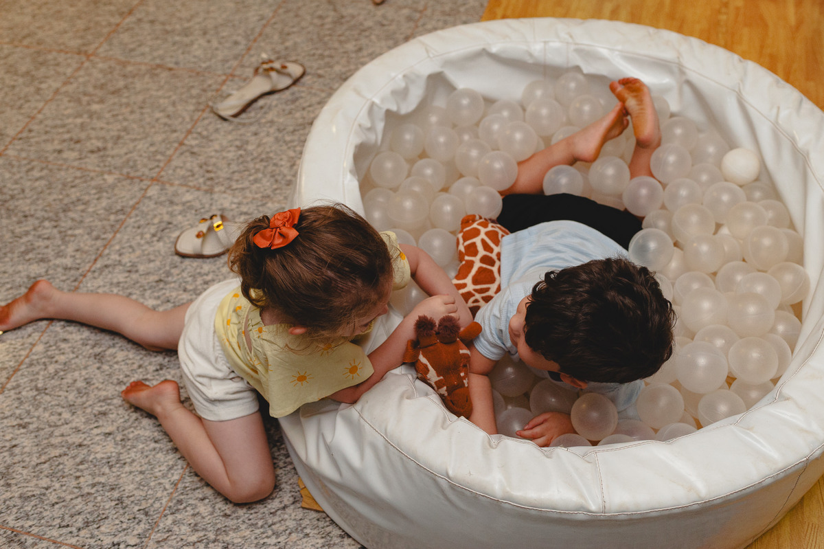 Menina e menino na piscina de bolinhas