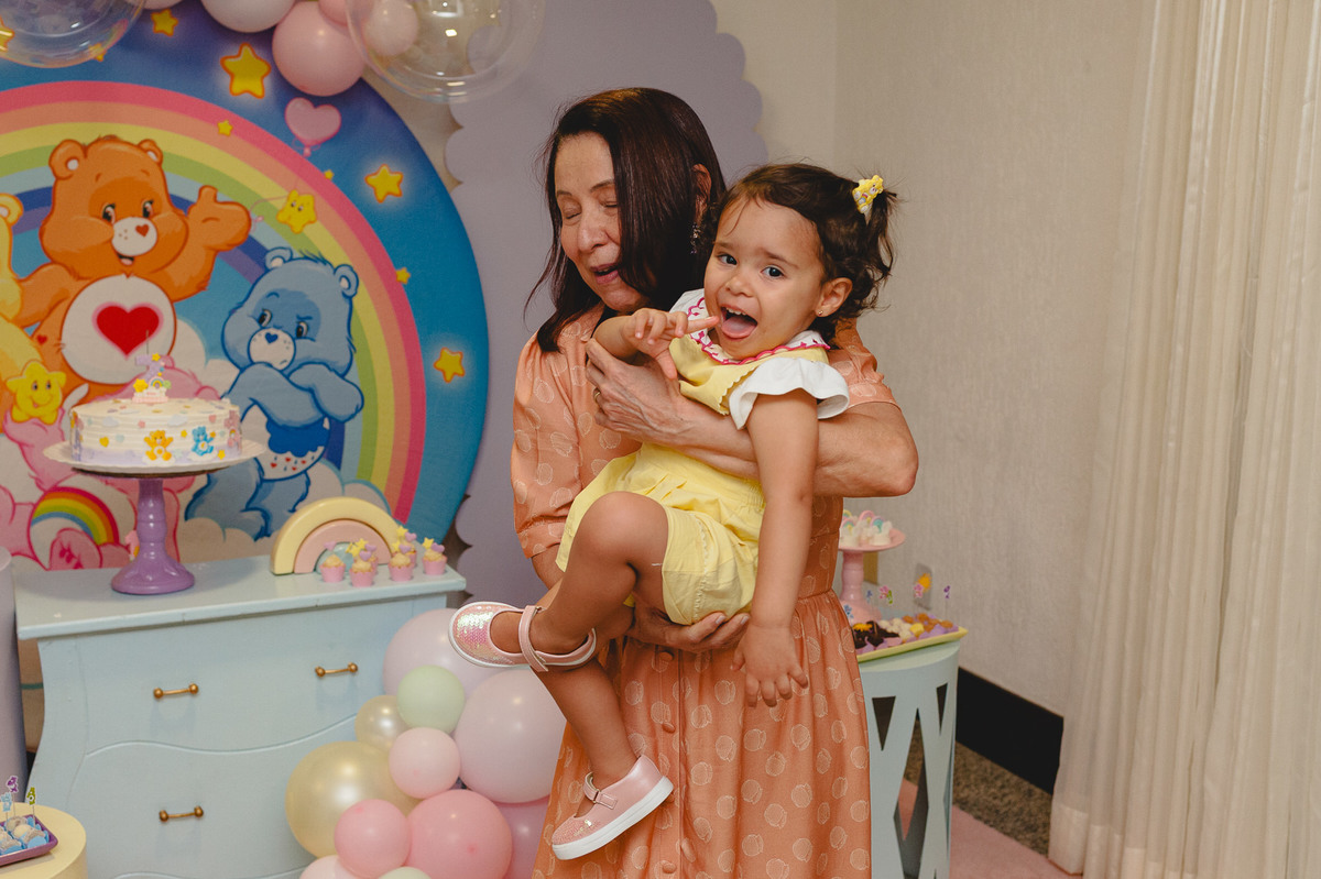 Menina feliz e sorridente no colo da avó